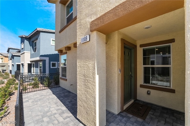 property entrance with a balcony and stucco siding