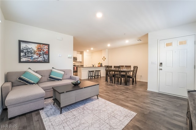 living area with baseboards, recessed lighting, and light wood-style floors