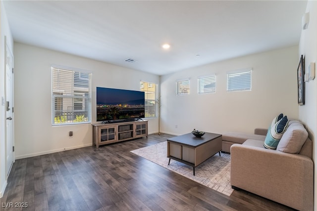 living room featuring baseboards, visible vents, and dark wood-style flooring