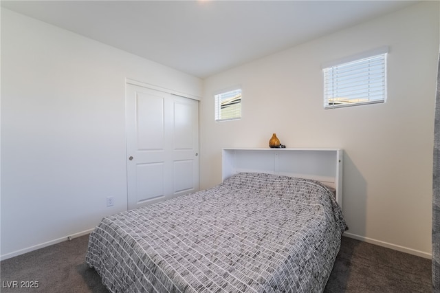 bedroom featuring a closet, dark carpet, and baseboards