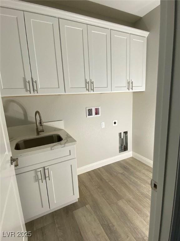 laundry area featuring cabinet space, wood finished floors, hookup for an electric dryer, washer hookup, and a sink