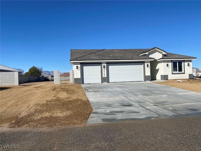 single story home featuring a garage, driveway, and stucco siding