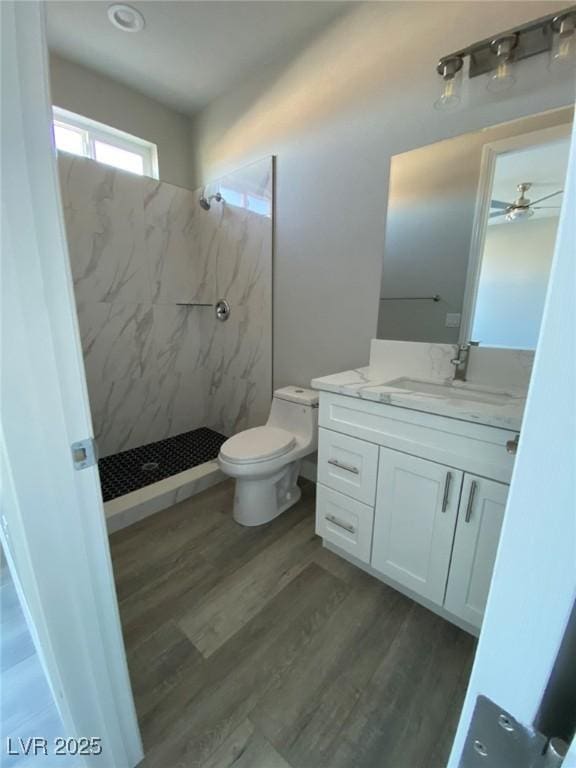 full bathroom with toilet, vanity, a shower stall, and wood finished floors