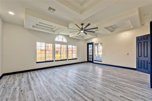 spare room featuring light wood-style flooring, visible vents, and baseboards