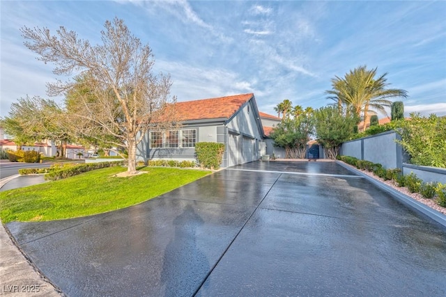 view of front of property featuring fence, a front lawn, and stucco siding