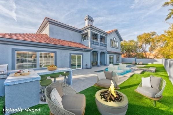 rear view of house with a fenced in pool, a fenced backyard, a chimney, a patio area, and stucco siding