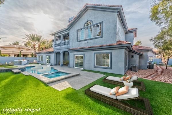 rear view of property with a fenced in pool, stucco siding, a lawn, an in ground hot tub, and cooling unit