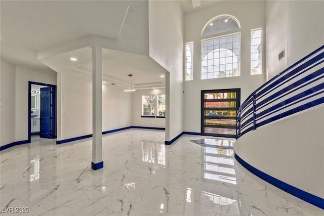 entryway with marble finish floor, recessed lighting, a towering ceiling, baseboards, and stairs