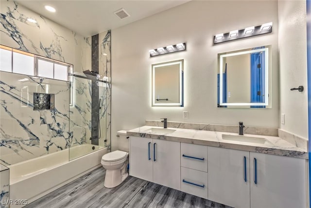 bathroom featuring shower / bathtub combination, toilet, a sink, and visible vents