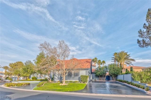 view of front of property featuring driveway, fence, a residential view, and stucco siding