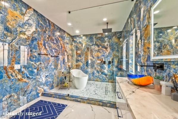 bathroom with a marble finish shower, vanity, and recessed lighting