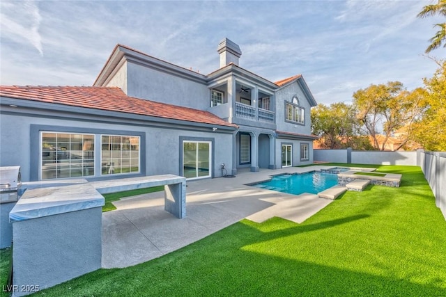 back of house with a balcony, a fenced backyard, a fenced in pool, and stucco siding