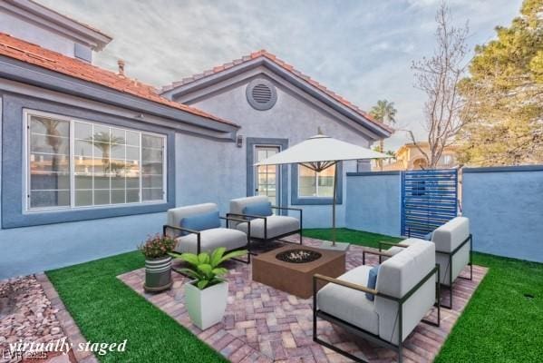 view of patio with an outdoor living space with a fire pit