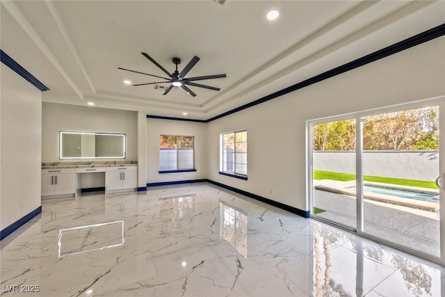 unfurnished living room with baseboards, a ceiling fan, marble finish floor, a tray ceiling, and recessed lighting