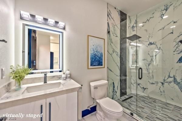 full bath featuring a marble finish shower, vanity, and toilet