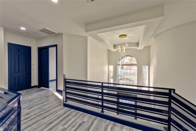 foyer entrance with recessed lighting, a raised ceiling, visible vents, light wood-style flooring, and baseboards