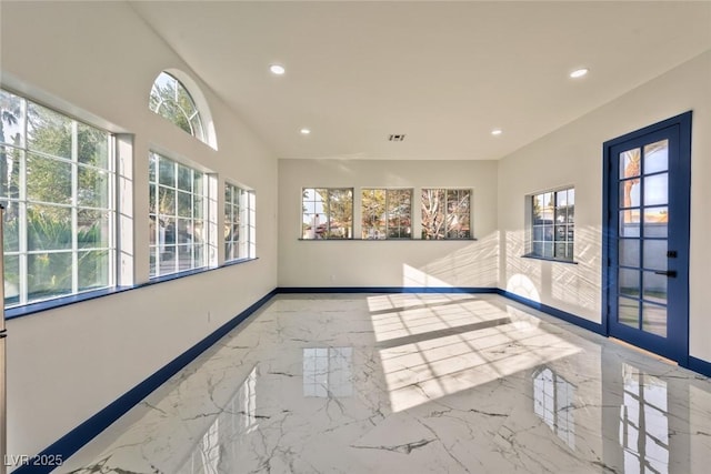 spare room featuring marble finish floor, recessed lighting, and baseboards