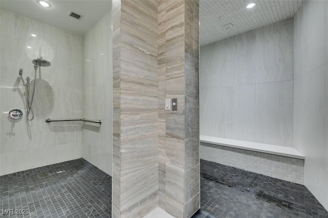 full bathroom featuring elevator, visible vents, a tile shower, and recessed lighting