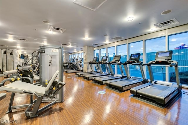 exercise room featuring wood finished floors and visible vents