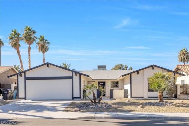 view of front of home featuring driveway, a chimney, an attached garage, fence, and central AC