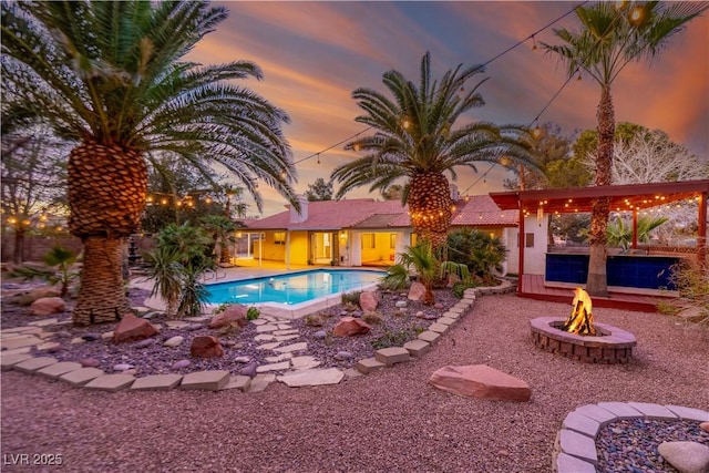 outdoor pool featuring a patio area and a fire pit