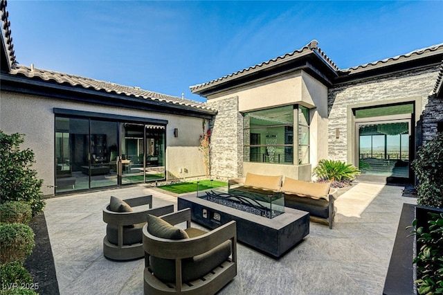 view of patio with an outdoor living space with a fire pit