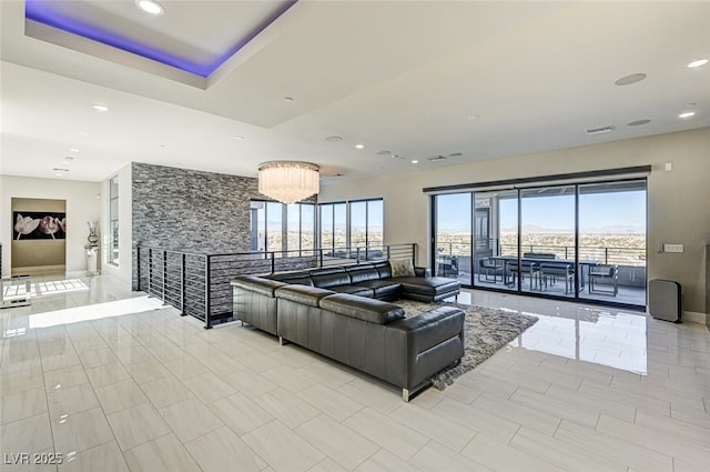 living room with recessed lighting, a raised ceiling, visible vents, and baseboards