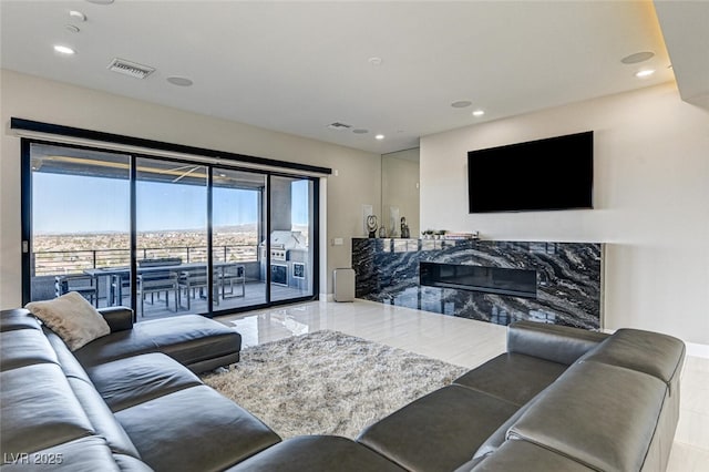 living room with recessed lighting, visible vents, and a premium fireplace