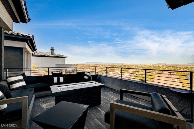 wooden terrace with an outdoor living space with a fire pit and a mountain view