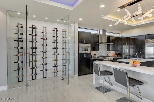 wine area featuring a tray ceiling and recessed lighting