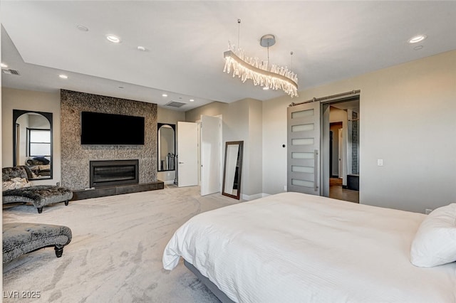 bedroom featuring a large fireplace, a barn door, light colored carpet, and recessed lighting