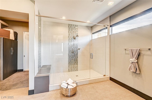 bathroom featuring tile patterned flooring, visible vents, a shower stall, and baseboards