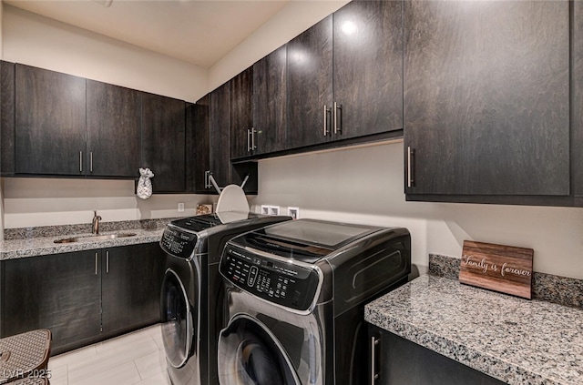 washroom with washing machine and clothes dryer, a sink, and cabinet space