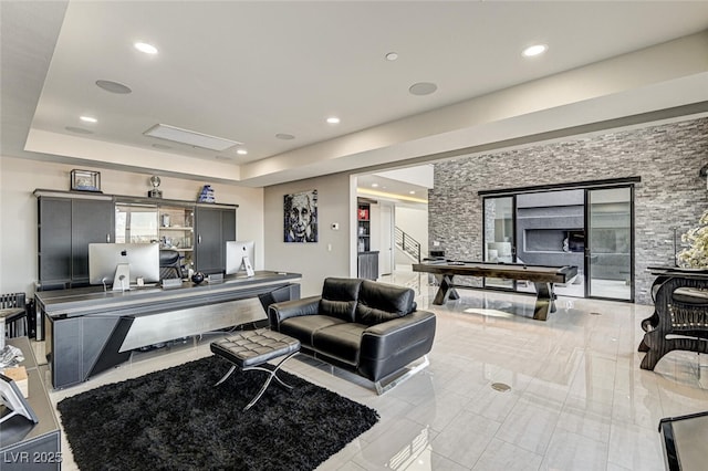 living area with a tray ceiling and recessed lighting