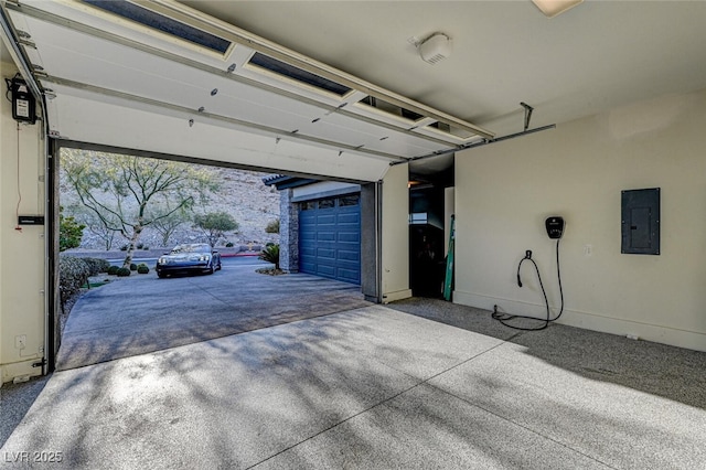 garage featuring electric panel and baseboards