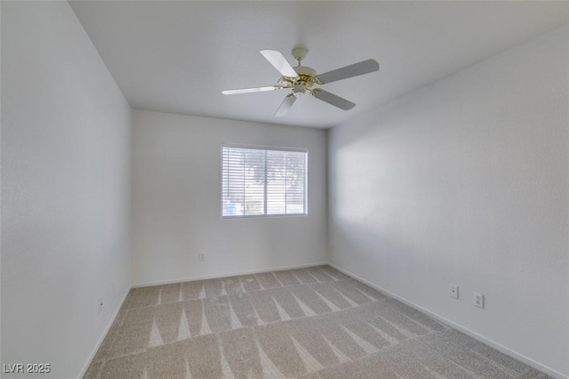 empty room with a ceiling fan, light carpet, and baseboards