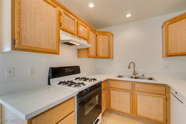 kitchen featuring light countertops, light brown cabinetry, a sink, white appliances, and under cabinet range hood