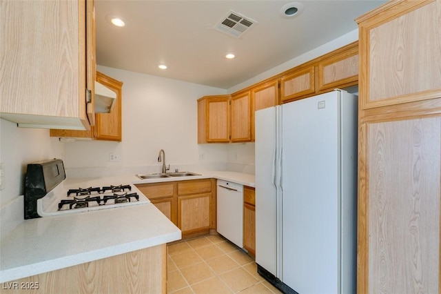 kitchen with light countertops, visible vents, light brown cabinetry, a sink, and white appliances