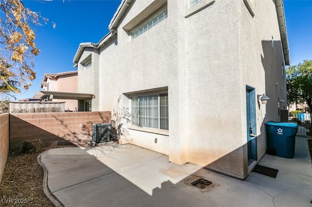 rear view of property with a pergola, a patio area, fence, and stucco siding