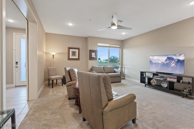 living area featuring light carpet, baseboards, visible vents, and a ceiling fan