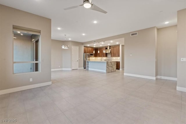 unfurnished living room with a ceiling fan, recessed lighting, visible vents, and baseboards