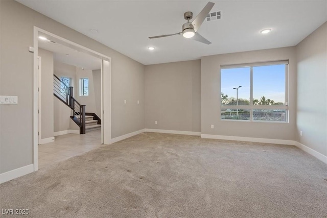 unfurnished room with light carpet, stairs, visible vents, and baseboards