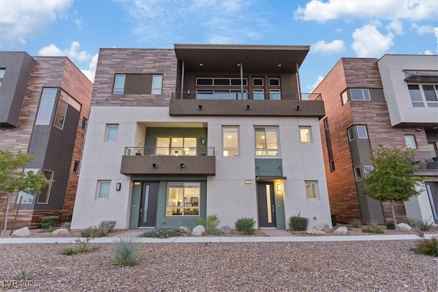 rear view of house featuring stucco siding