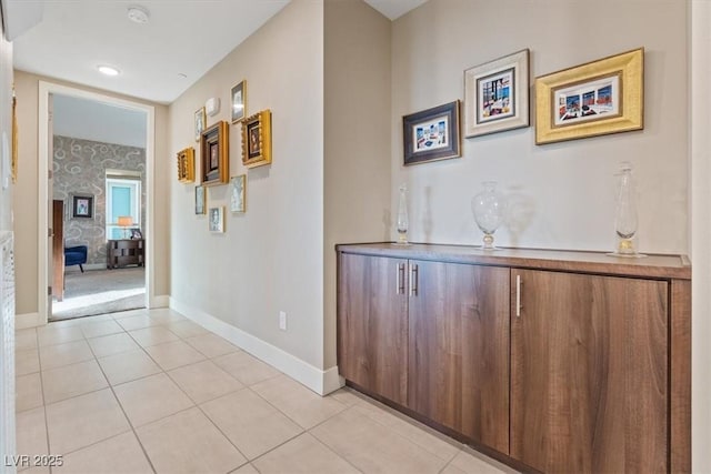 hall with baseboards and light tile patterned floors