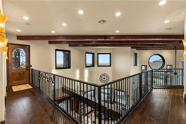 hall with dark wood-type flooring, recessed lighting, beam ceiling, and visible vents