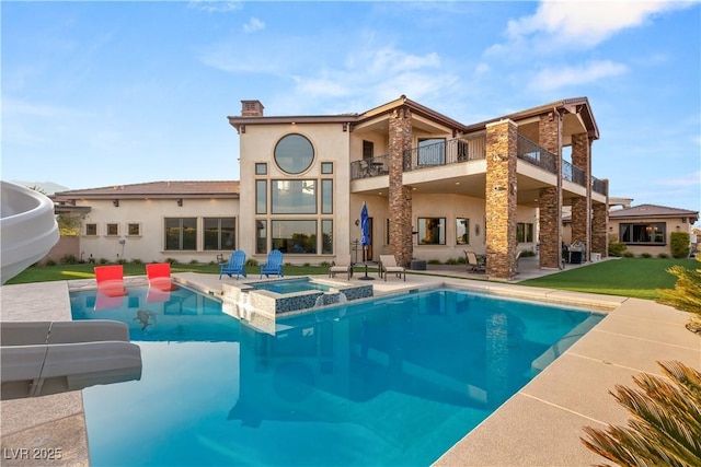 back of property featuring a pool with connected hot tub, a chimney, and stucco siding