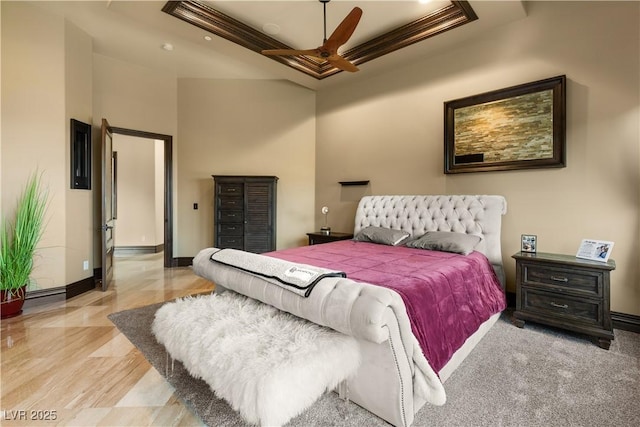 bedroom with a raised ceiling and baseboards