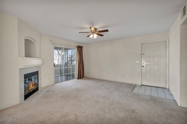 unfurnished living room featuring a fireplace, visible vents, a ceiling fan, and light colored carpet