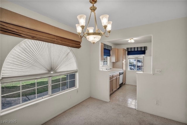 kitchen featuring light colored carpet, light countertops, light brown cabinetry, a sink, and dishwasher