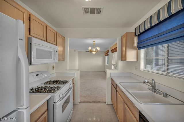 kitchen featuring light countertops, visible vents, hanging light fixtures, a sink, and white appliances